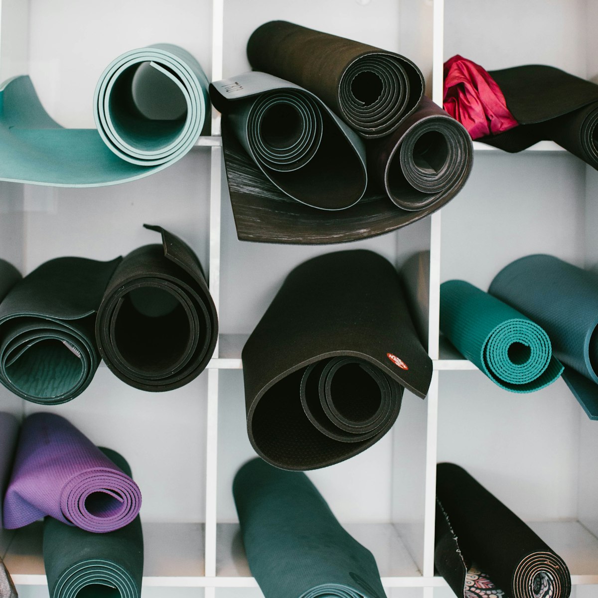 Esterilla, bloques y accesorios de yoga dispuestos en un estudio